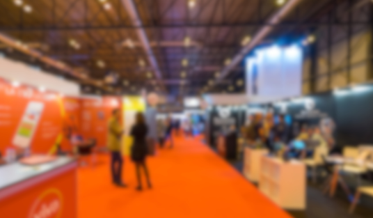 Moderner Messestand mit Besuchern auf orangefarbenem Gang