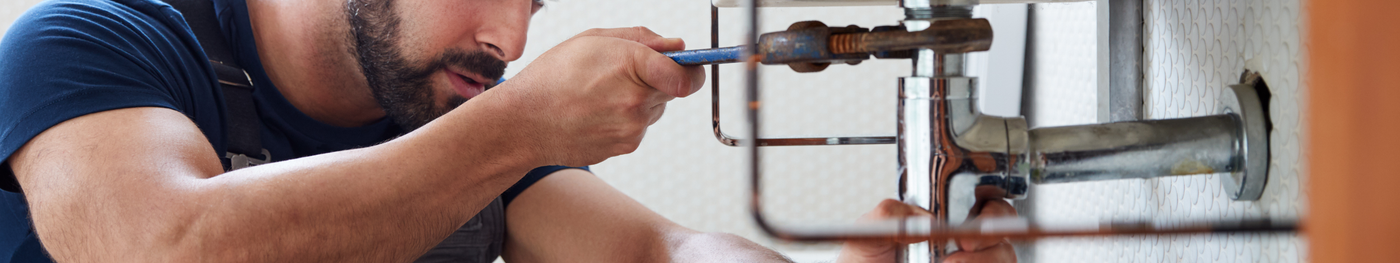 SHK Handwerker montiert Rohrinstallation im Badezimmer